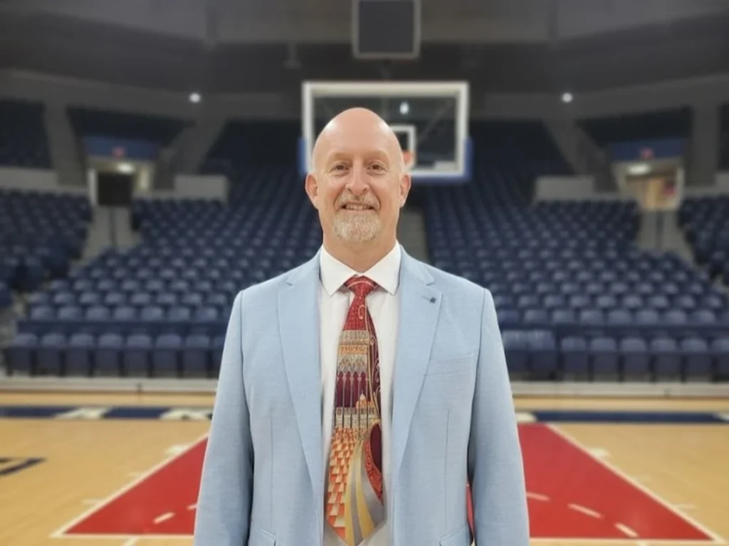 Rogues coach Doug Partridge poses for a picture on a basketball court